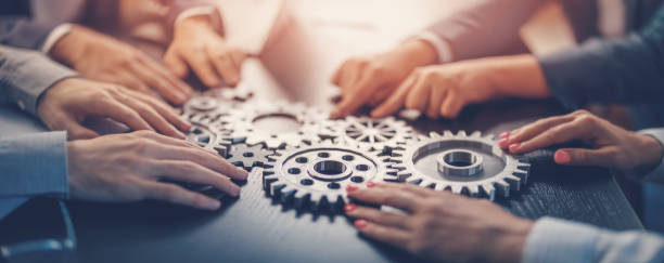 istock People joining cog wheel on the black desk. 1653217070