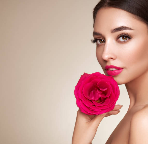 istock Beautiful young woman a rose flower 1653284513