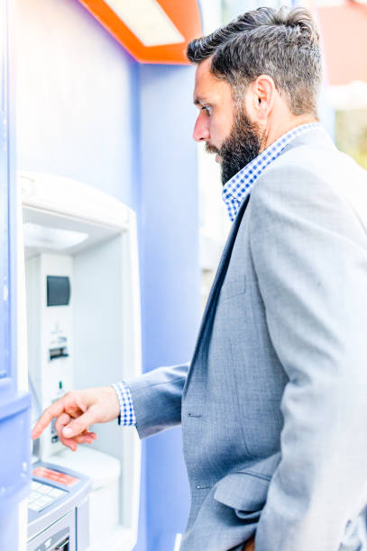 istock Well dressed business man in a suit uses an ATM 1653296042