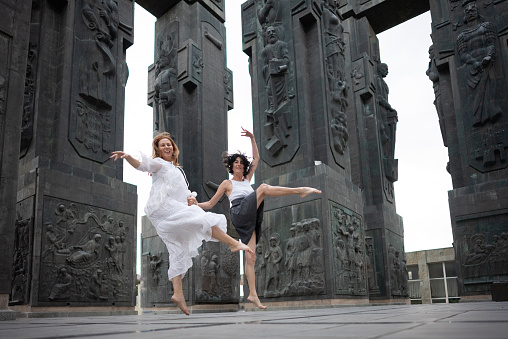 Mature females friends jumping in front of the Chronicle of Georgia .