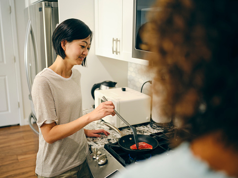 Women friends spending time together in a home kitchen.