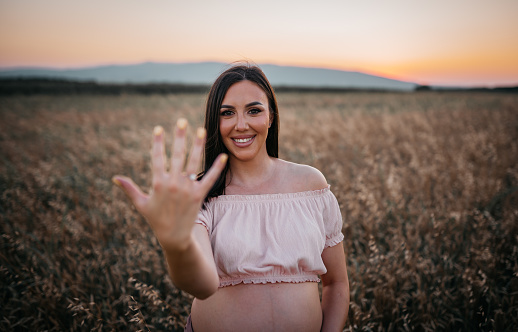 Young pregnant woman enjoying the Sunset