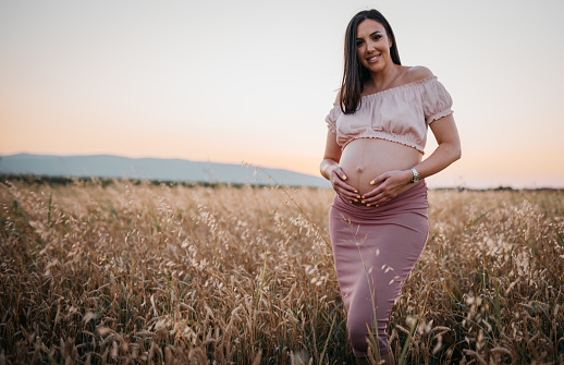 Beautiful Pregnant Woman in a Wheat Field