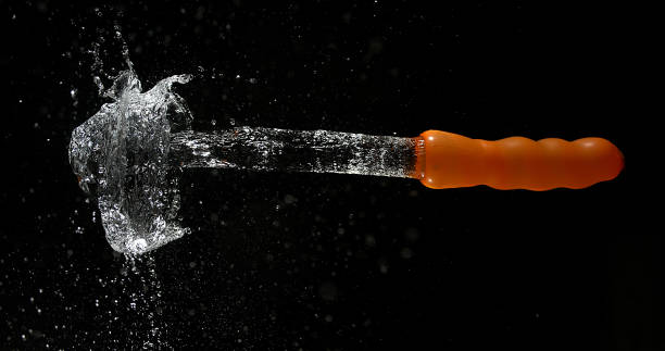 istock Shot Breaking Water Filled Orange Balloon 1653398969