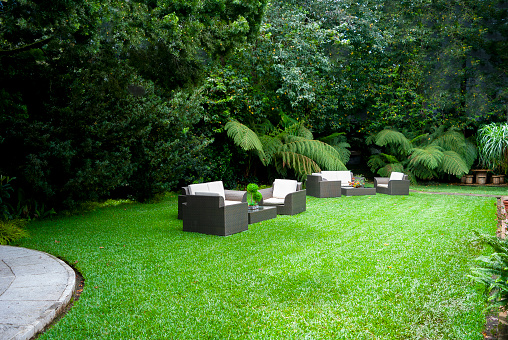 Modern Patio With Sofa, Armchairs, Coffee Table And Garden View Background