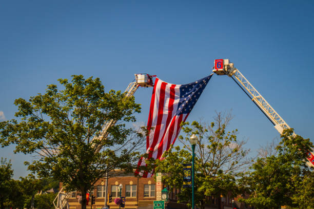 Newport, Vermont, USA- August 8, 2023: hanging the American flag over the parade route featuring all the fire departments in the Northeast Kingdom area of Vermont