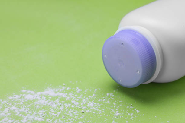 istock Bottle and scattered dusting powder on light green background, space for text. Baby cosmetic product 1653428531