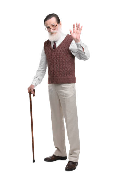 istock Senior man with walking cane waving on white background 1653452310