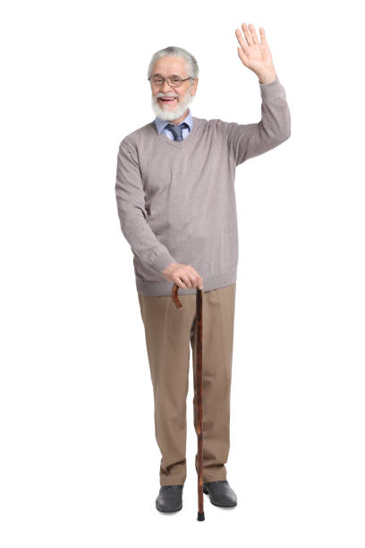 istock Senior man with walking cane waving on white background 1653455573