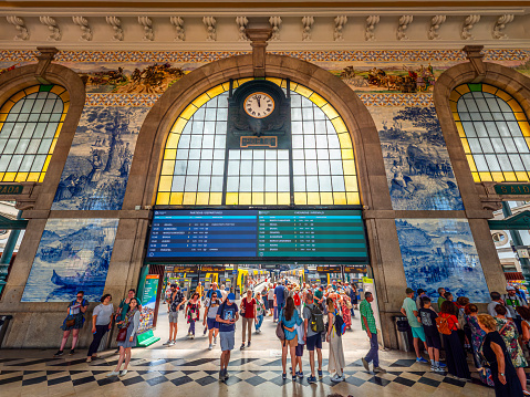 Porto, Portugal, Europe - June 26, 2023: Interior view of the famous train station and Railway gate, with tourists getting ready and consulting the timetable for their destination in Porto