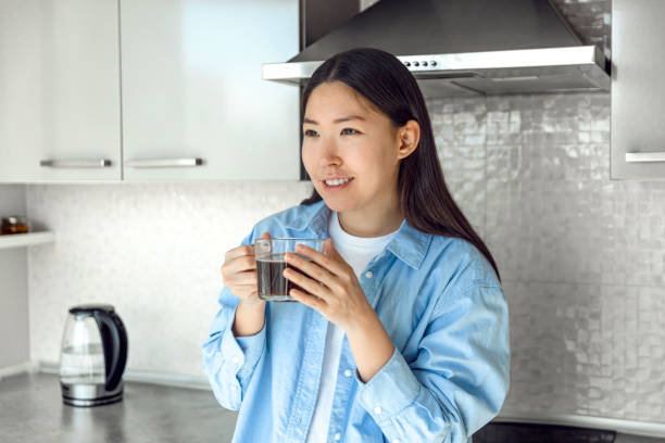 istock Beautiful asian woman drinking coffee on the kitchen 1653475381