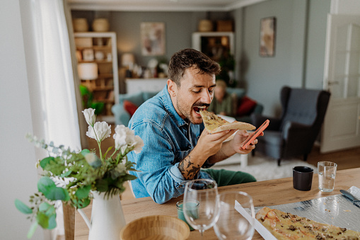 Mid adult man eating pizza at home