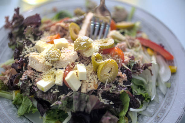 Dive into a world of vibrant flavors with our exquisite mixed salad! Featuring crisp purple lettuce, cherry tomatoes, cheese cubes, zesty olives, and more. A blend of freshness and culinary art. Capture healthy gourmet essence. Delicious Salad Medley: Fresh and Vibrant Ingredients caesar salad food salad tuna stock pictures, royalty-free photos & images