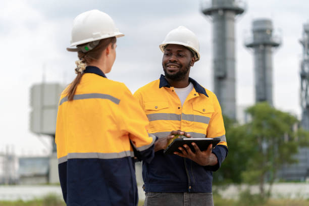 istock Innovation and Quality within the realm of Field Operations, where a dedicated team of surveyors is hard at work. Electrical engineer using computer and discuss with team to increase capacity at power plant. 1653768563