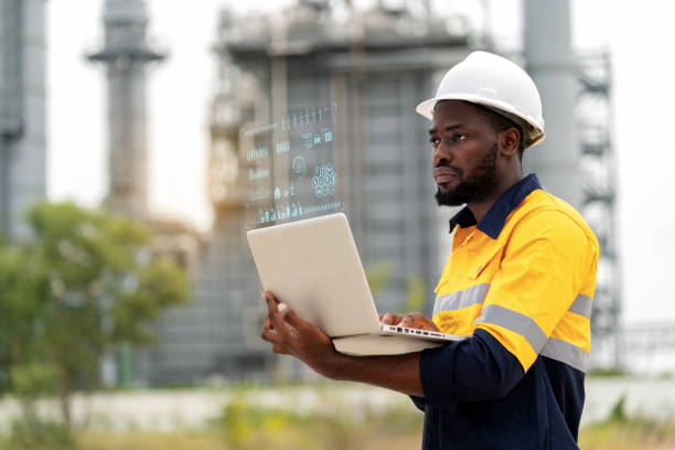 istock African American engineer making a significant impact at a power plant. Confidently beside a power plant generator to reduce factory waste to zero. Analyzes data on laptop utilizing graphic interface dashboard with high technology. 1653768686