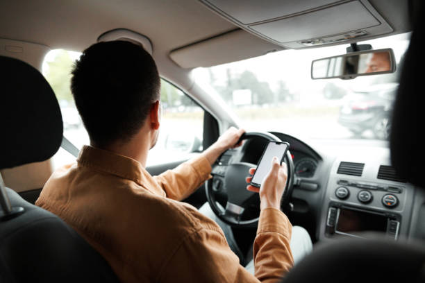istock Rear view of man text messaging while driving car in the city 1653821338