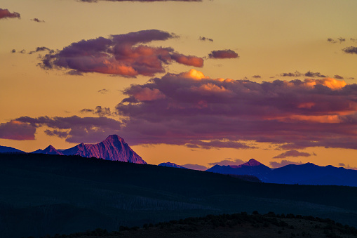 Capitol Peak Colorado 14er Landscape at Sunset - High peak with knife-edged ridge bathed in golden alpenglow light as sun is setting. Summer view, Elk Mountains, Colorado USA.