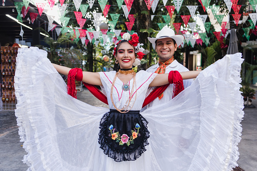 Latin couple of dancers wearing traditional Mexican dress from Veracruz Mexico Latin America, young hispanic woman and man in independence day or cinco de mayo parade or cultural Festival party