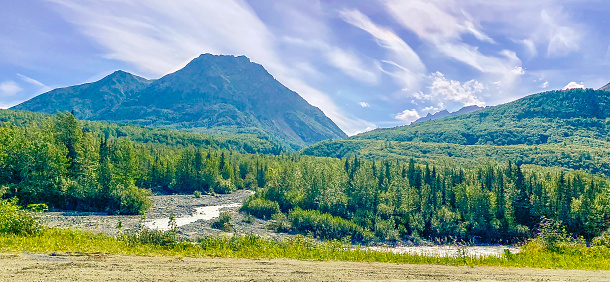 Thomson River, Kamloops, BC with mountain range and railway bridge in distance.