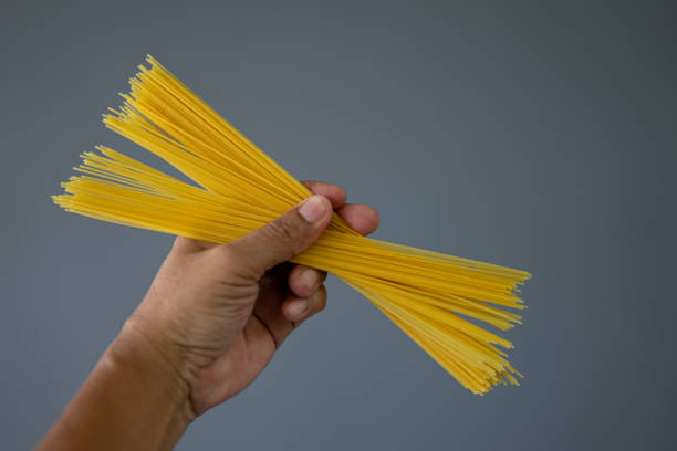 istock Close up hand holding spaghetti 1654145862