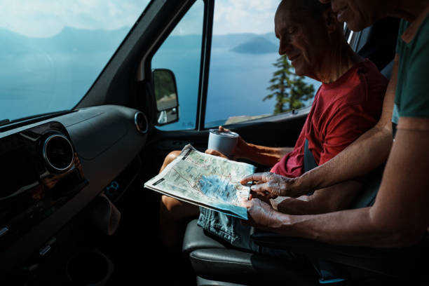 istock Vibrant senior couple looking on road trip looking at map 1654176422