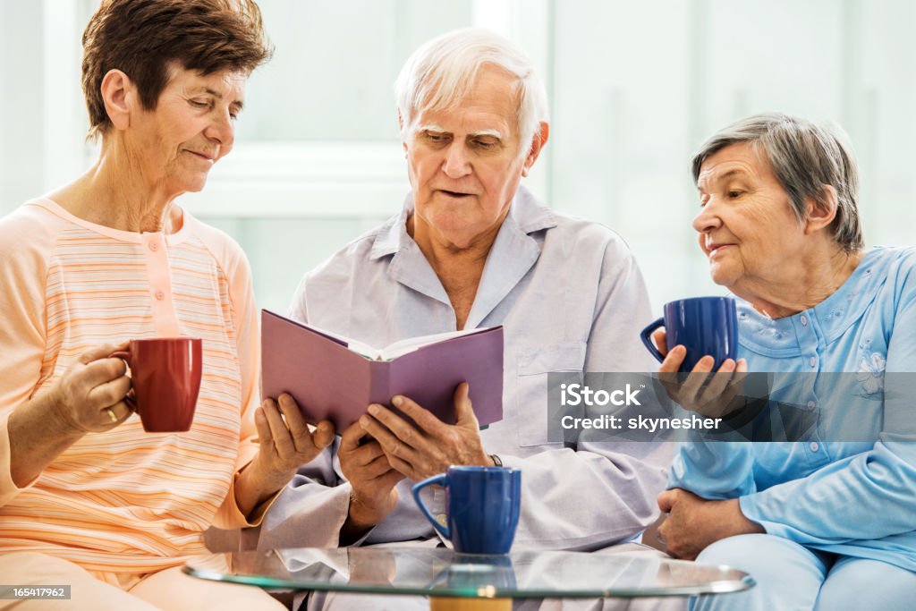Senior personas disfrutando mientras lee un libro. - Foto de stock de Amistad libre de derechos