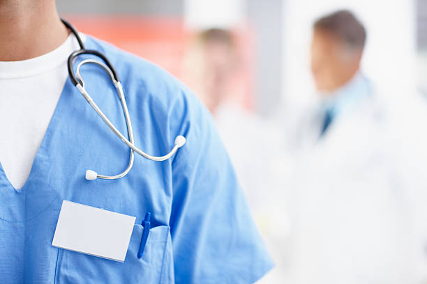 Close-up of a doctor in scrubs with stethoscope Cropped image of a male surgeon wearing a nametag alongside copyspace medical scrubs stock pictures, royalty-free photos & images
