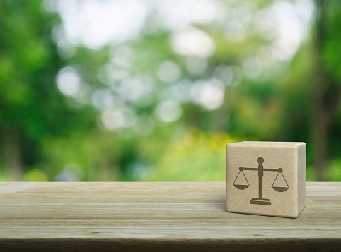 Law icon on wood block cube on wooden table over blur green tree in park, Business legal service concept