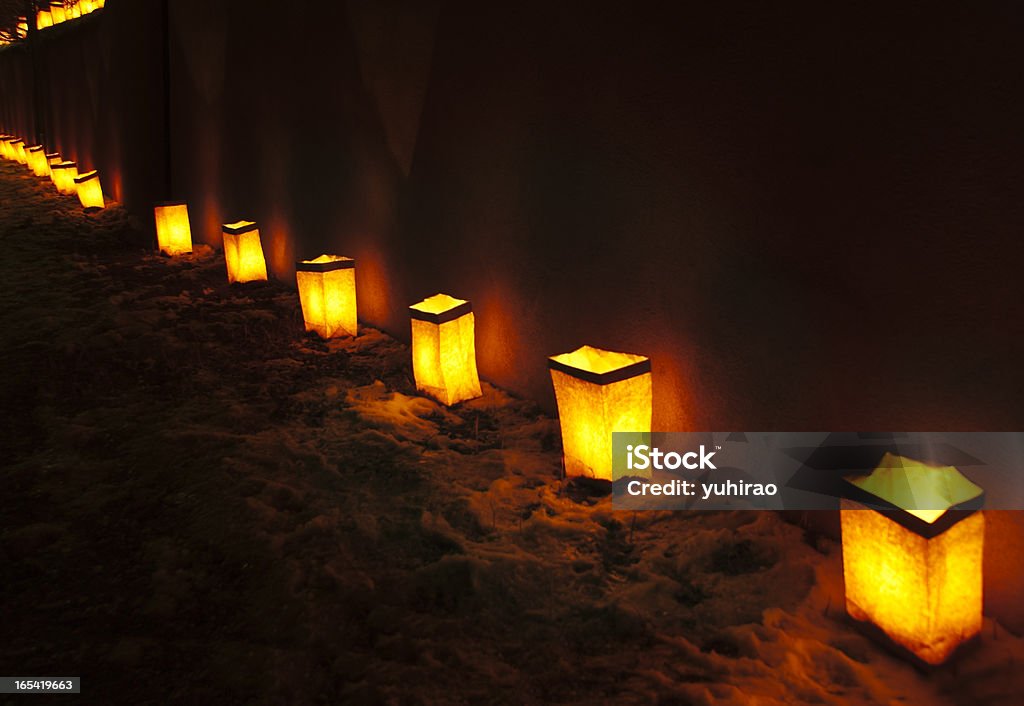 Luminarias at Christmas Chrismas Luminarias (Christmas lantern composed of a candle placed inside a paper bag) on an adobe wall with snow on the ground. Taken at Christmas Walk on Christmas Eve in Santa Fe, NM, USA. Luminaria Stock Photo