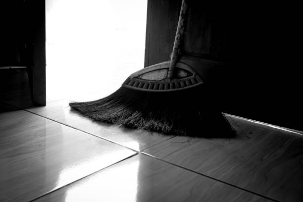 A palm fiber broom leaning against the mouth of the door.