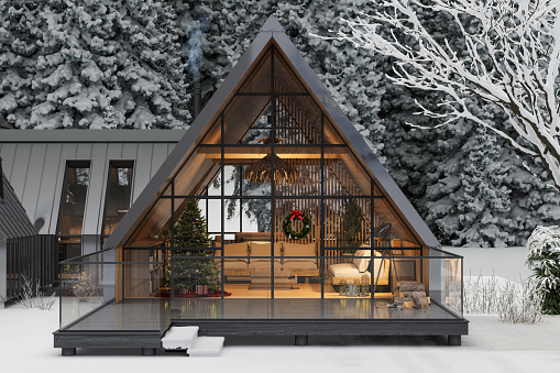 Modern Chalet In Winter With Christmas Decoration. Living Room With Christmas Tree And Gift Boxes. Snow Covered Trees On Background