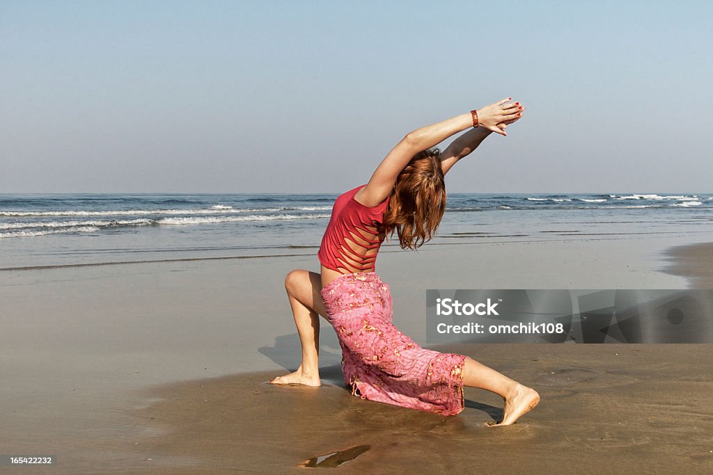 Giovane donna in posa del guerriero yoga - Foto stock royalty-free di Adulto