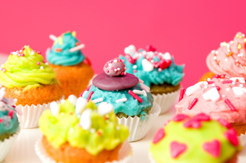 Colorful cupcakes on a pink background