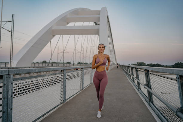 istock Young woman enjoys a brisk run on the bridge 1654252469