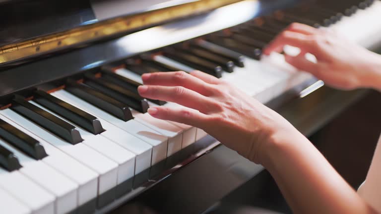 hands of woman play piano