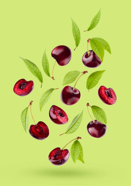 istock Bright red cherry with green leaves as flow fly or fall as art composition. Whole, pieces fruits on colorful green background with shadow. Summer fruits for advertising, design, label product, poster. 1654285243