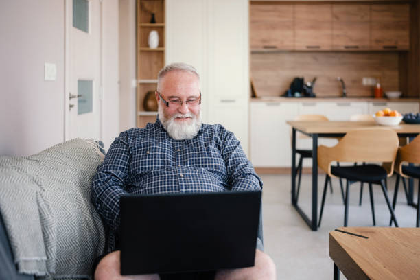 istock Mature man using laptop for online conference in his home 1654285260