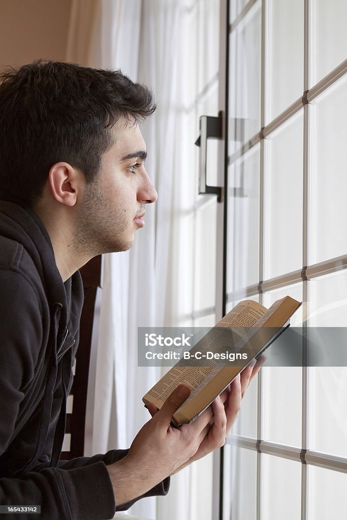 Mężczyzna Trzymając biblię wygląda przez okno sprawiając - Zbiór zdjęć royalty-free (Biblia)
