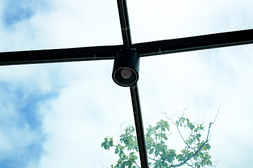 Picture of a large LED spotlight with cable installed on the glass on the roof of a building.