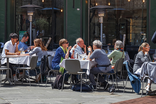 Bergamo, Italy - May 22, 2019: Unknown people are sitting at tables in an outdoor cafe in the historic part of Bergamo.