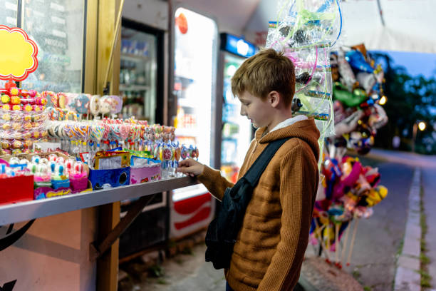 Young boy's face lights up with a lollipop in store, capturing pure delight