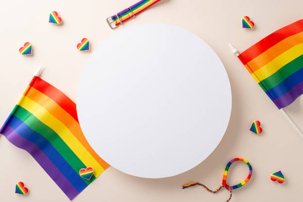 istock Flat lay composition of LGBT attributes including blank round podium for text rainbow hearts bracelet and flags on beige background 1654408593