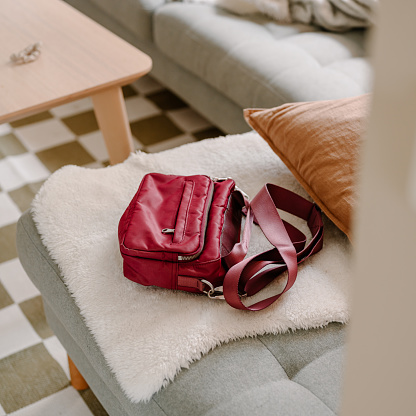 Modern hand bag lying on sofa at home 
Photo taken indoors in natural light