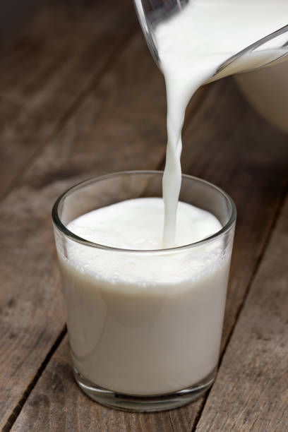 istock milk pouring in glass from jug on table 1654453580