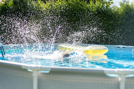 A child splashing in his own pool in the garden