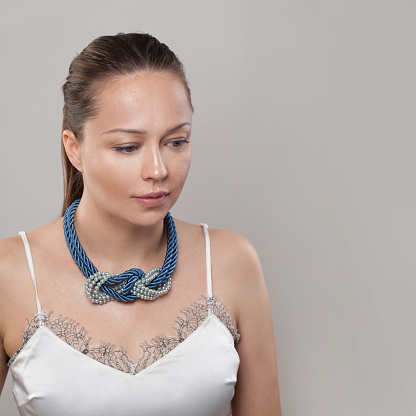 Blue and grey necklace on neck of attractive woman