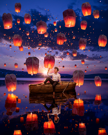 Beautiful man at the boat with sky lanterns