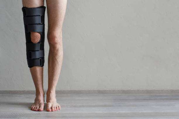 istock Leg in black knee brace on gray background 1654528407