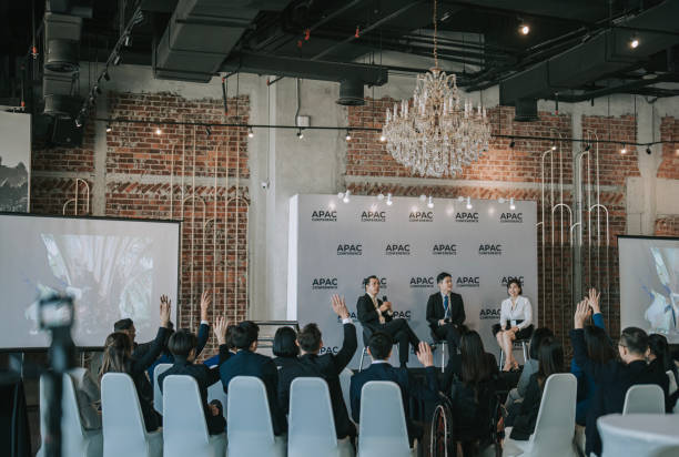 istock back view multiracial Active Asian Seminar participant raise hands during business conference sharing session 1654534778