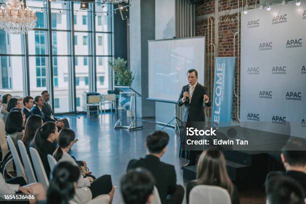 Asian Mature Businessman Coaching Motivation Speech In Business Conference Meeting Seminar During Convention Center Stock Photo - Download Image Now